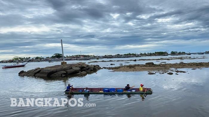 Sejumlah warga mendayung sampan kecil menuju kapal nelayan saat air laut surut di Pelabuhan Bum Besar, Desa Pongok, Bangka Selatan.