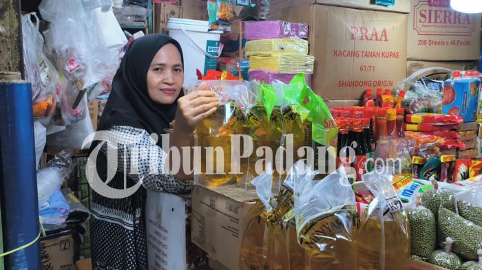 HARGA MINYAK GORENG- Pedagang sembako, Ida Sumarni, berada di kedainya, Blok 1 Pasar Raya, Kampung Jawa, Kecamatan Padang Barat, Kota Padang, Sabtu (6/6/2026). Sejumlah pedagang sebut harga MinyaKita masih normal di Pasar Raya Padang, belum ada kenaikan.