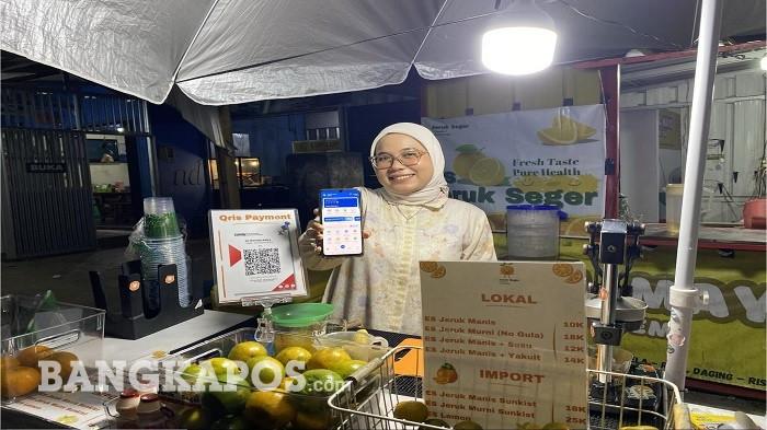 Pelaku UMKM Es Jeruk Seger menunjukkan layanan pembayaran menggunakan QRIS BRI di kawasan Air Itam, Kota Pangkalpinang.