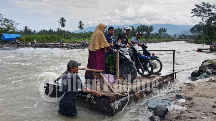 ANTRE RAKIT- Pengendara sepeda motor menyeberangi aliran sungai dengan menaiki rakit di kawasan Nagari Anduriang, Kecamatan 2x11 Kayu Tanam, Kabupaten Padang Pariaman, Sumatera Barat, Rabu (6/5/2026).