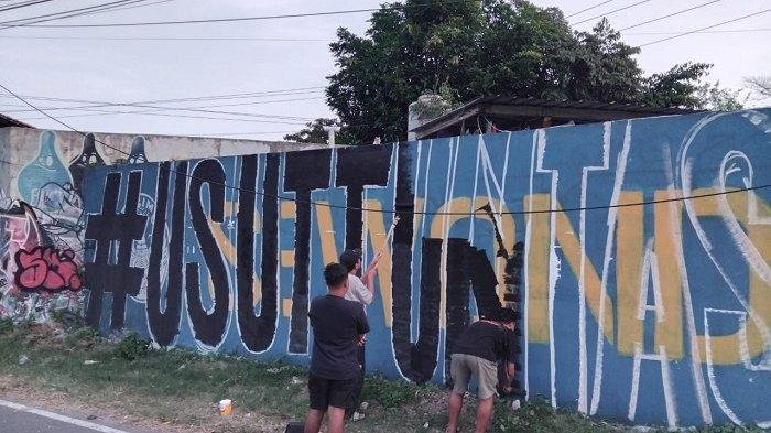 KRITIK LEWAT MURAL: Sejumlah suporter PSIM Yogyakarta saat membuat mural di sebidang dinding yang berada di Jalan Ringroad Selatan, Panggungharjo, Sewon, Bantul, Senin (1/6/2026).
