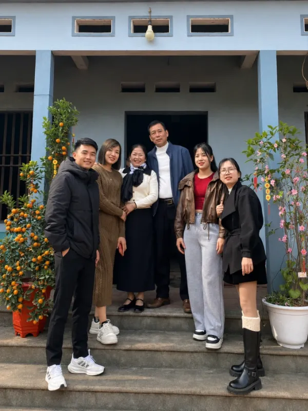 Mrs. Hang and her husband (white shirt) with their biological children and husband's children, Tet 2026. Family photo provided