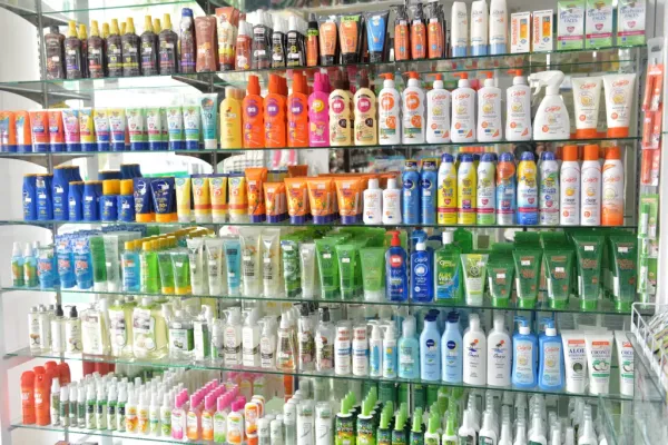 A store shelf stocked with a variety of sun protection products like sunscreen, tanning oil, and after-sun lotions.