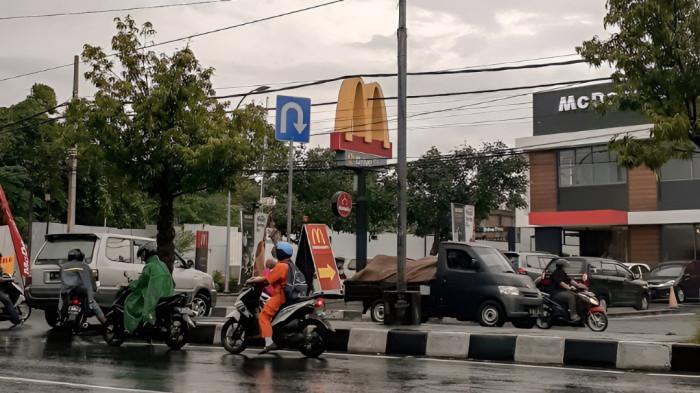 JALANAN BASAH- Terlihat jalanan basah setelah diguyur hujan deras. Sejumlah warga berkendara motor tampak menggunakan mantel hujan ketika beraktivitas.