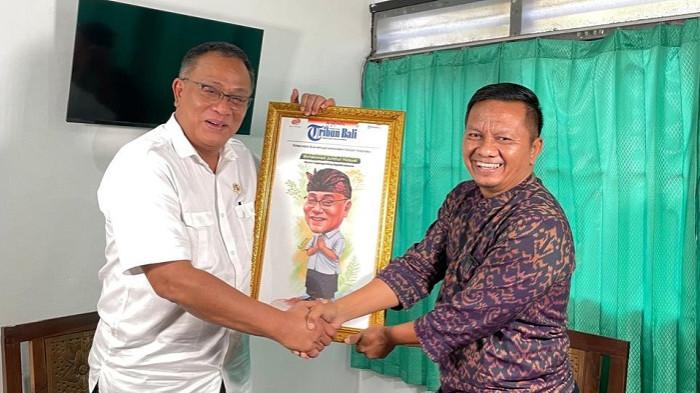 BERI CINDERAMATA - Menteri LH Jumhur Hidayat menerima cinderamata berupa karikatur dari Pemimpin Redaksi Tribun Bali Komang Agus Ruspawan usai wawancara.