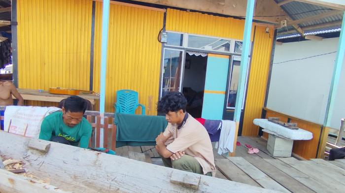 PEMBUAT PERAHU -- Omin Badu (pria berkaus hijau) sedang membuat perahu (Sumber : TribunGorontalo/Rahmat Hambali)