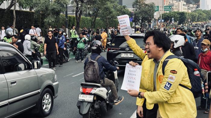 BUNYIKAN KLAKSON - Massa aksi menggunakan almamter Universitas Indonesia mengajak  masyarakat yang melintas di Jalan Sudirman arah Semanggi, ikut menyuarakan keresahan, Jumat (12/6/2026). (Tribunnews/Alfarizy)