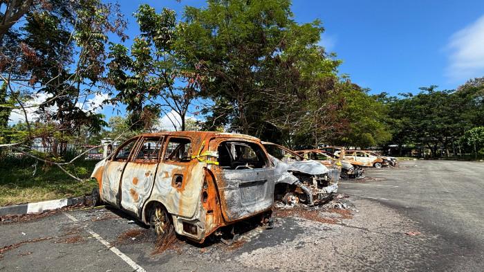 SISA KERUSUHAN - Bangkai kendaraan yang hangus terbakar masih terlihat di kawasan Stadion Lukas Enembe, Kabupaten Jayapura, Jumat (12/6/2026). Kendaraan tersebut merupakan sisa kerusuhan seusai laga Persipura Jayapura melawan Adhyaksa FC Banten pada 8 Mei 2026 lalu.