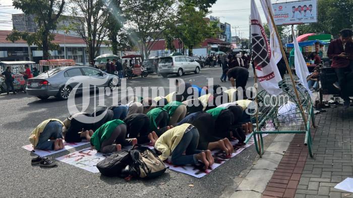 AKSI UNJUK RASA- Mahasiswa salat asar berjamaah di belakang keranda saat aksi demo yang digelar di kantor DPRD Sumbar, Senin (15/6/2026).