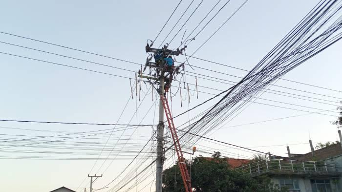 TERSENGAT LISTRIK - Petugas teknisi memperbaiki kabel di simpang empat Pasar Tradisional Pohgading, Pringgabaya, Lombok Timur, Senin (15/6/2026).