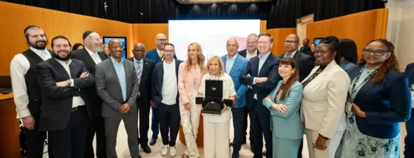 A group of men and women pose with a London Jewelers Diamond.