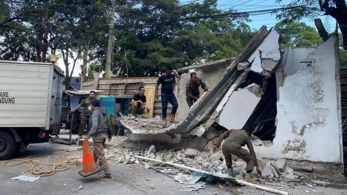 Satpol PP Kota Bandung saat membongkar garasi yang dibangun di trotoar Jalan Ambon, Kota Bandung, Jawa Barat, Minggu (14/6/2026).