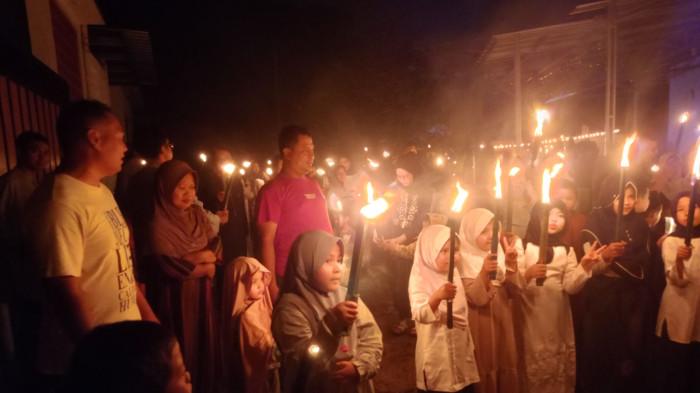 PAWAI OBOR - Para orang tua tengah mendampingi anaknya mengikuti pawai obor menyambut tahun baru Islam, yang berlokasi di wilayah Desa Cintaraja, Singaparna, Kabupaten Tasikmalaya, Senin (15/6/2026).
