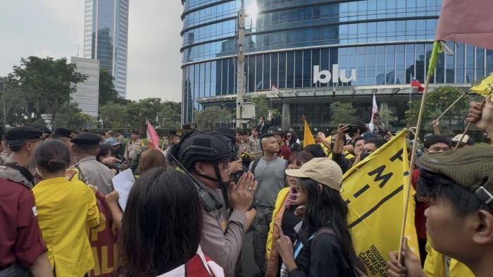 KAPOLSEK - Momen Kapolsek Menteng, AKBP Braiel Arnold Rondonuwu mengenakan helm taktis, memberikan gestur tangan memohon saat terlibat adu mulut dan negosiasi alot dengan massa mahasiswa yang memaksa masuk ke Bundaran HI, Jakarta Pusat, Senin (15/6/2026).