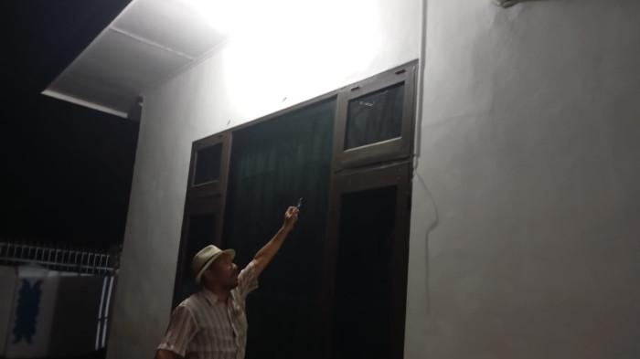 DITEMBAK : Seorang wartawan mengamati jendela rumah Wakil Bupati Deli Serdang, Lom Lom Suwondo yang ditembak OTK, Senin (15/6/2026). Kasus ini masih diselidiki pihak kepolisian.