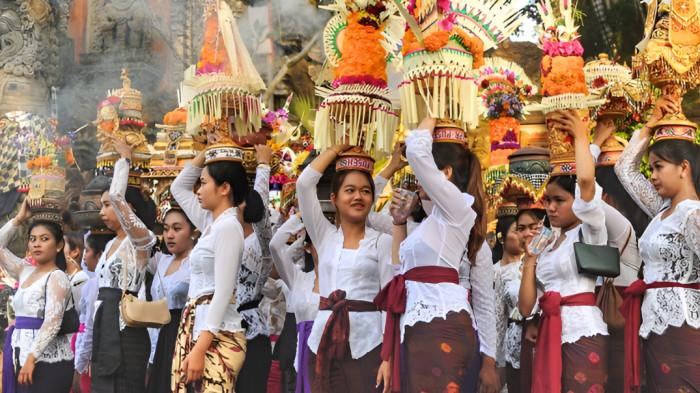 RITUAL- Sejumlah masyarakat Hindu Bali saat bersiap mengadakan ritual keagamaan. Sejumlah wanita terlihat membawa baki persembahan.