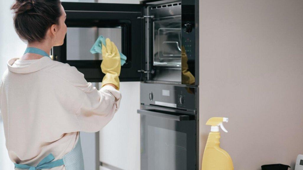 Ilustrasi membersihkan microwave.