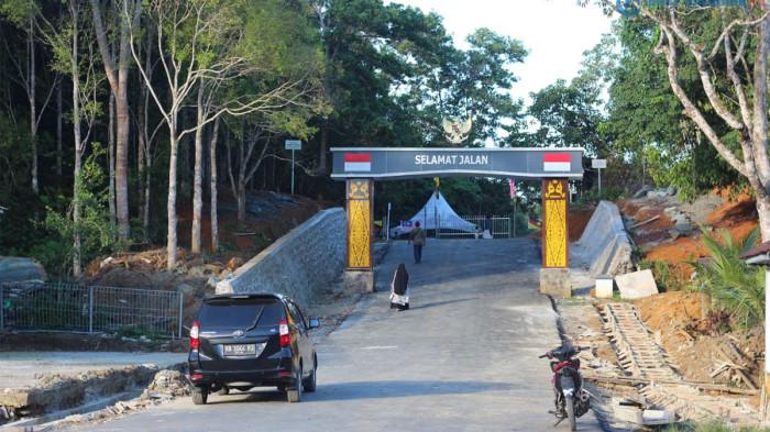 PLB TEMAJUK - Sejumlah pengunjung lokal menengok tapal batas negara di pintu Pos Lintas Batas (PLB) Temajuk, Kecamatan Paloh, Kabupaten Sambas, Kalimantan Barat, Minggu 14 Juni 2026. PLB Temajuk akan diresmikan pemerintah pada Agustus 2026 mendatang sebagai perluasan akses perbatasan hingga magnet wisatawan mancanegara Pantai Temajuk.