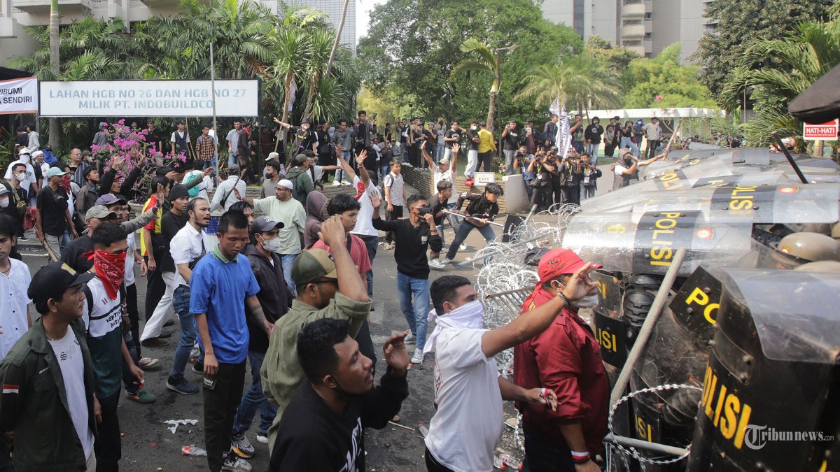 RICUH - Petugas gabungan TNI Polri bertahan dari serangan kelompok massa yang menolak eksekusi pengosongan lahan Hotel Sultan, Jakarta, Kamis (18/6/2026). Sekelompok massa tersebut melempari petugas dengan benda-benda yang berada disekitar. Pantauan Tribunnews.com di lapangan kericuhan terjadi usai panitera PN Jakarta Pusat membacakan putusan eksekusi lahan. Tribunnews/Jeprima