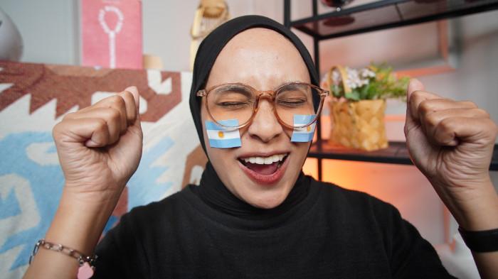 Wanita asal Boyolali mengenakan stiker Argentina di wajah sebagai bentuk dukungan dalam Piala Dunia 2026, di Kota Solo, Jawa Tengah, Senin (15/6/2026).