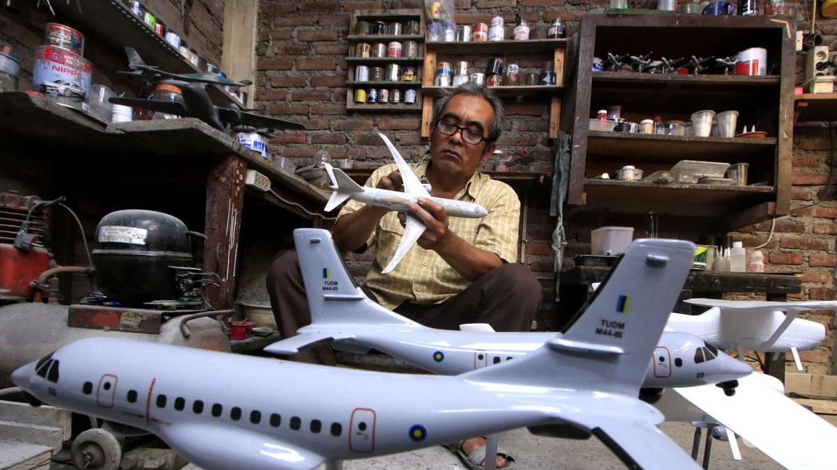 Owner Tiara Flight Miniature, Deden Sopian (55) mengerjakan pembuatan miniatur pesawat terbang dari bahan baku resin di rumah produksinya, Jalan KH Usman Dhomiri, Desa Padasuka, Kecamatan Cimahi Tengah, Kota Cimahi, Jawa Barat, Rabu (18/12/2024). Deden merintis usaha miniatur pesawat terbang sejak 2007 saat masih bekerja sebagai mekanik di maskapai penerbangan PT Merpati Nusantara Airlines, dan mulai diseriuskan pada 2018 setelah berhenti kerja. Berbagai miniatur pesawat dibuat di rumah produksi ini, mulai dari jenis Sukhoi, Airbus, Boeing, pesawat tempur, hingga miniatur roket dan satelit. Produk kerajinannya banyak dipesan sejumlah instansi terkait penerbangan di dalam negeri dan pesanan perorangan dari berbagai wilayah di Indonesia hingga mancanegara. Miniatur pesawat yang dibuatnya mulai ukuran 9 sentimeter hingga 1,5 meter dengan harga jual mulai Rp 150 ribu hingga Rp 20 juta per unit. (TRIBUN JABAR/GANI KURNIAWAN)