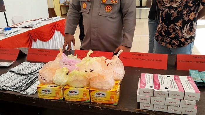OBAT ILLEGAL - Kapolres Belitung Timur, AKBP Indra Feri Dalimunthe didampingi Kasat Reskrim, AKP I Made Yudha Suwikarna dan Kasi Humas, Ipda Asep Achmadi saat melaksanakan konferensi pers di Joglo Graha Patriatama Mapolres Beltim, Jumat (19/6/2026) sore. Agenda ini memaparkan keberhasilan Tim Panah Pemburu dalam mengamankan dua pemilik toko kelontong di Kecamatan Manggar berinisial WDJ dan SNR, serta menyita ribuan butir obat tanpa izin resmi seperti Tramadol, Trihexyphenidyl, Codela, Neomethor, dan Mextril siap edar.