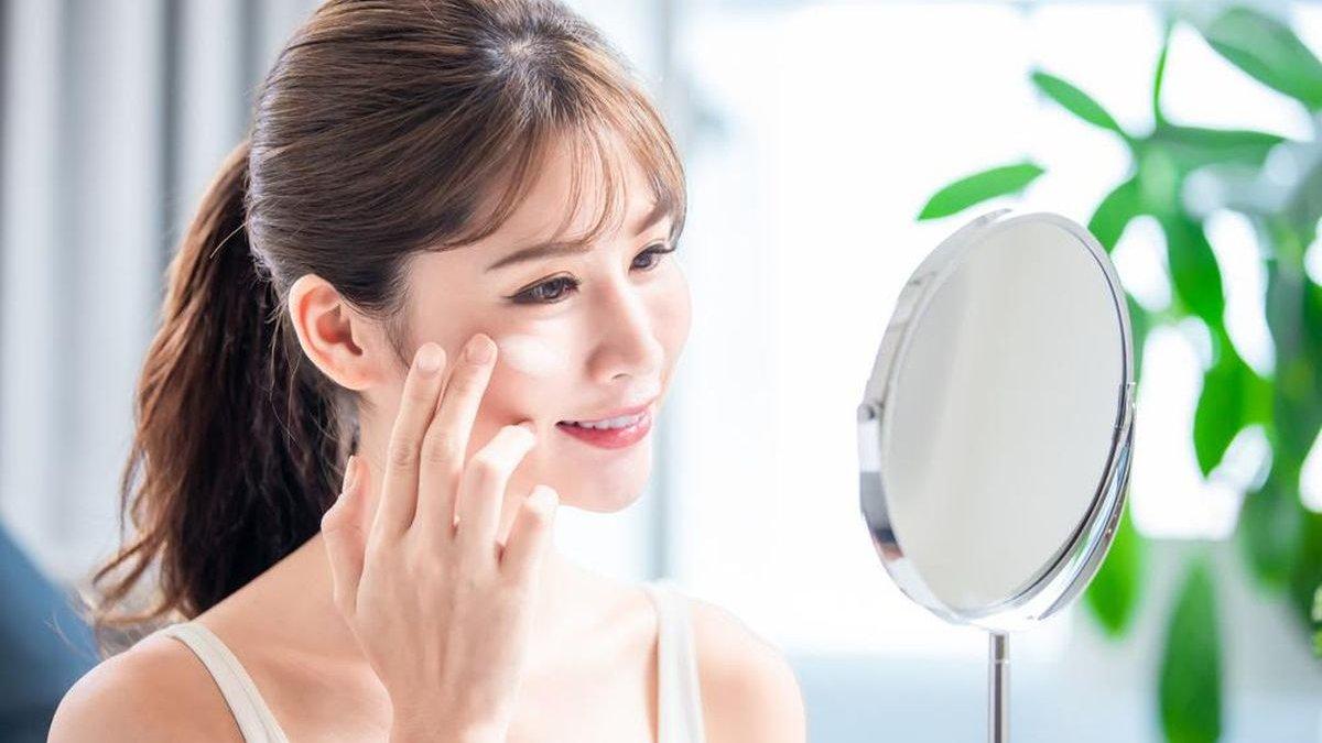 Ilustrasi wanita re-apply sunscreen.