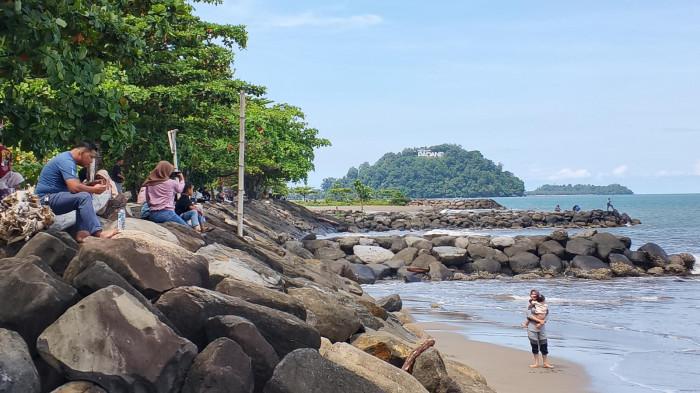 WISATA PANTAI- Suasana pengunjung memadati kawasan Pantai Padang (Taplau), Kota Padang, Sumatera Barat, Minggu (3/5/2026). Pemerintah Kota Padang mengimbau seluruh pelaku usaha menjaga kenyamanan wisatawan, termasuk tidak mewajibkan pengunjung berbelanja saat memarkirkan kendaraan.