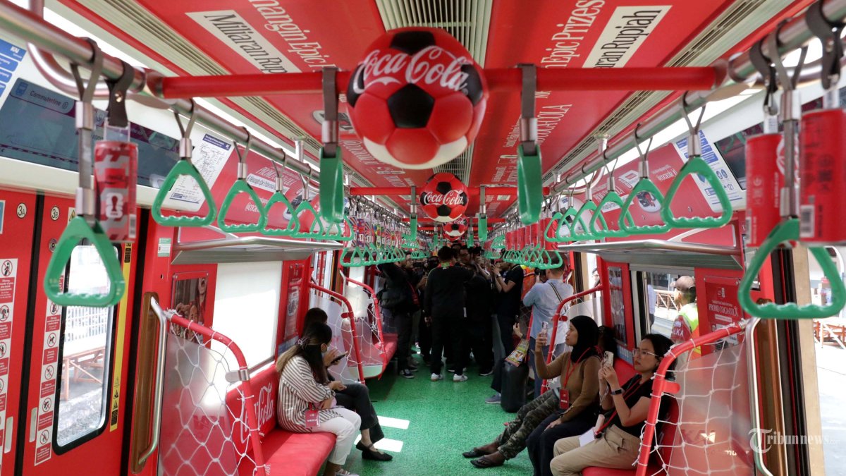 Penumpang berada di dalam Commuter Line Tematik Piala Dunia 2026 di Stasin Jakarta Kota, Jakarta, Rabu (17/6/2026). Menghadirkan semangat FIFA World Cup™ ke dalam keseharian masyarakat, Coca-Cola Indonesia menghadirkan pengalaman bertema turnamen di sejumlah rangkaian Commuter Line pada rute Cikarang (jalur biru) dan Bogor (jalur merah), yang menjangkau ribuan komuter Jakarta hingga akhir Juni. Instalasi khusus bertema FIFA World Cup ini mengubah perjalanan sehari-hari menjadi bagian dari perayaan sepak bola, sehingga setiap perjalanan menjadi kesempatan untuk merasakan dan berbagi semangat dari ajang olahraga paling populer di dunia. TRIBUNNEWS/IRWAN RISMAWAN