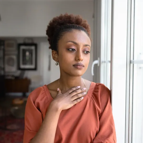 thoughtful woman looking out window dissatisfied with her work life