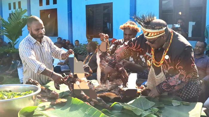 BAKAR BATU - Bupati Jayawijaya, Atenius Murib, beserta Ketua Korwil, Moses Meage saat memotong daging Babi (B2) di Asrama Mahasiswa Jayawijaya, Sabtu (20/6/2026)