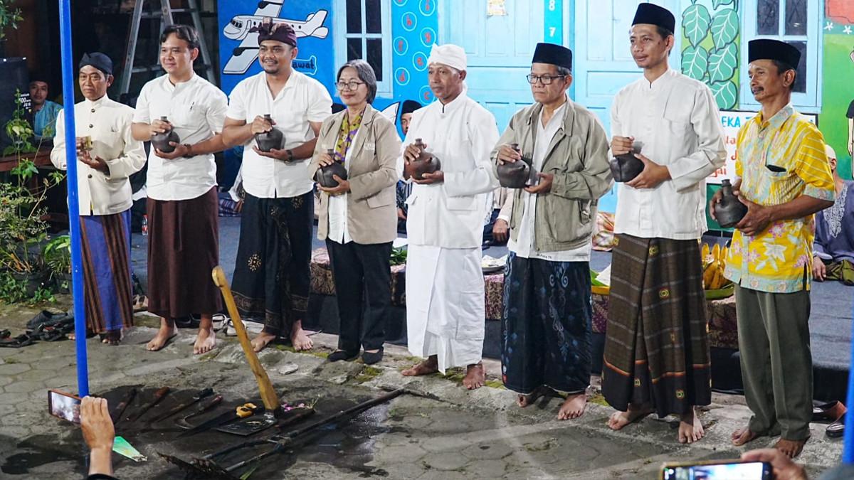 JAMASAN ALAT PERTANIAN - Kepala Desa Prawatan Sabiq Muhammad bersama tokoh lintas agama melakukan prosesi jamasan alat pertanian menggunakan air dari tujuh sumber mata air dalam kegiatan Umbul Donga Lintas Iman, Jamasan, dan Jagongan Refleksi Desa, di Balai Desa Prawatan, Jumat (19/6/2026) malam.