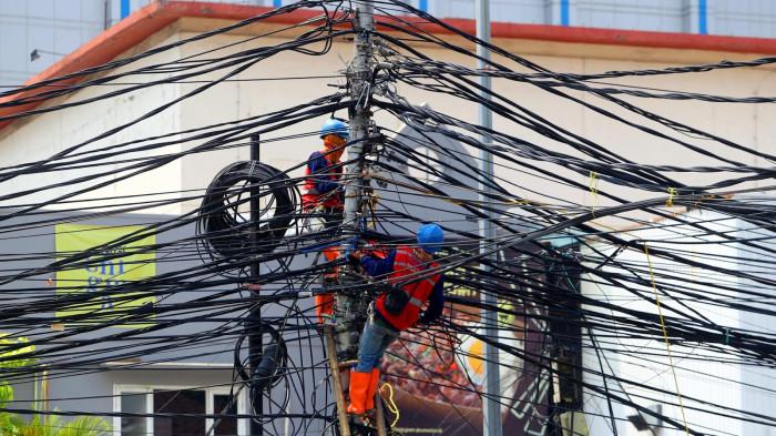 PEMBENAHAN KABEL SEMRAWUT - Petugas tengah membereskan saluran kabel atas yang semrawut di Kawasan Jalan Agus Salim, Jakarta Pusat, Selasa (9/12/2019). Selain merusak pemandangan dan keindahan Ibukota, kabel tersebut seringkali menjuntai akibat terseret kendaraan yang agak tinggi.