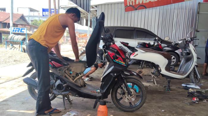 HARGA OLI - Pengendara ganti oli di bengkel wilayah Desa Topoyo, Kecamatan Topoyo, Kabupaten Mamuju Tengah, Sulawesi Barat, Minggu (21/6/2026). (Sandi/Tribunsulbar)