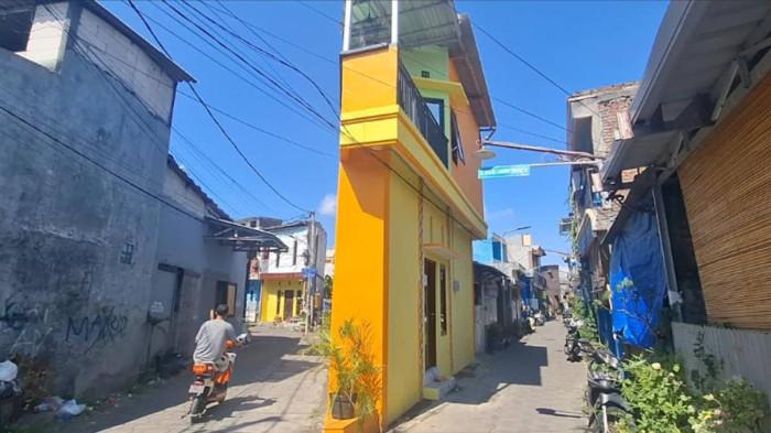 VIRAL.- Penampakan rumah kontrakan berbentuk meruncing, terletak di persimpangan jalan penduduk di Jalan Bulak Cumpat Srono IV, Kelurahan/Kecamatan Bulak, Kota Surabaya, Senin (22/6/2026). Meski mungil, rumah kontrakan itu dicari 2 sampai 3 pasangan suami istri yang baru menjalin rumah tangga