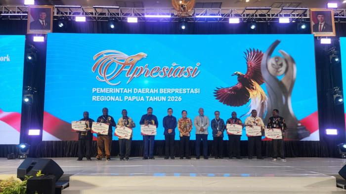 MOMEN PENGANUGERAHAN JUARA - Para kepala daerah se-Tanah Papua berfoto bersama usai menerima penghargaan atas keberhasilan tata kelola wilayahnya dalam acara Apresiasi Pemerintah Daerah Berprestasi Regional Papua Tahun 2026 di Ballroom Hotel Suni Abepura, Kota Jayapura, pada Senin malam (22/6/2026). Apresiasi Kemendagri itu diserahkan oleh Wakil Menteri  II Bima Arya dan Ceo Tribun Network Dahlan Dahi.