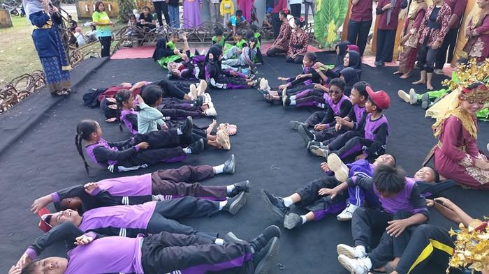 PERMAINAN LAWAS - Sejumlah murid Sekolah Dasar (SD) dipandu oleh Tetua Adat sekaligus Dukun Kampung Desa Lilangan, Syahiril atau Kik Kun (63), saat mempraktikkan permainan tradisional Belitong di atas panggung Festival Seni Budaya Desa Lilangan, Kecamatan Gantung, Belitung Timur, Selasa (23/6/2026). Lewat tiga permainan legendaris yaitu Pong Pong Along, Jajak Setunju, dan Sapu Sapu Rengit, generasi muda diajak untuk kembali melatih kekompakan, kejujuran, dan sportivitas sekaligus mengalihkan ketergantungan dari gawai.