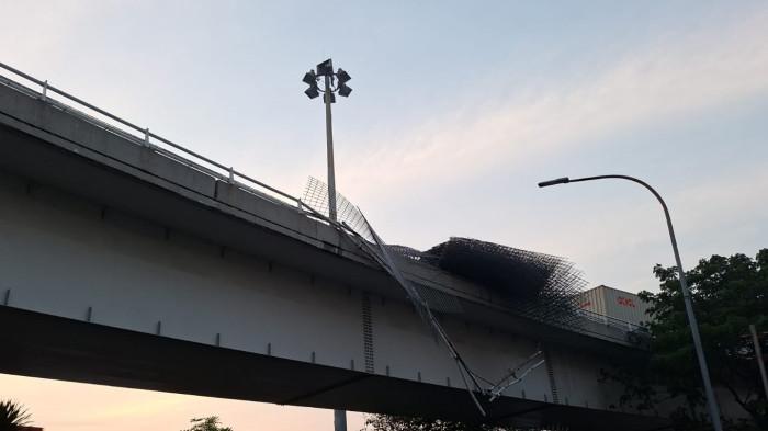TRUK GULING - sebuah truk trailer bermuatan pagar wiremesh terguling di Jalan Layang Tomang KM 13.400 arah barat, Rabu (24/6/2026) pukul 04.00 WIB.