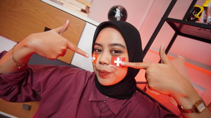 Wanita asal Karanganyar mengenakan stiker Swiss di wajah sebagai bentuk dukungan dalam Piala Dunia 2026, di Kota Solo, Jawa Tengah, Rabu (17/6/2026).(Tribun-Video.com/Akmal Khoirul Habib)