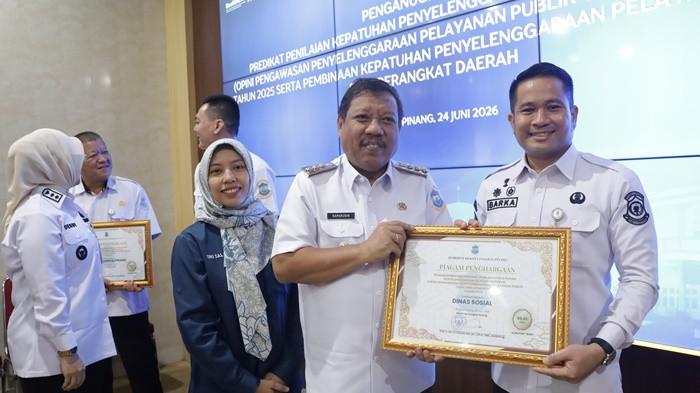 PIAGAM PENGHARGAAN -- Wali Kota Pangkalpinang, Saparudin, menyerahkan piagam penghargaan kepada perwakilan Dinas Sosial Kota Pangkalpinang usai meraih predikat kualitas baik dalam Penilaian Kepatuhan Penyelenggaraan Pelayanan Publik oleh Ombudsman Republik Indonesia Tahun 2025, di Smart Room Centre Kantor Wali Kota Pangkalpinang, Rabu (24/6/2026).