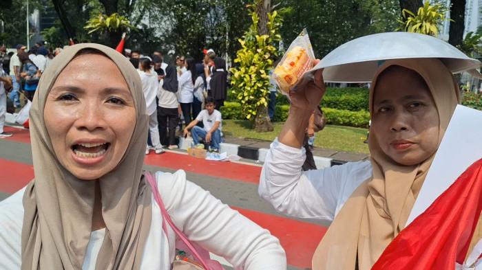DUKUNG MBG - Dua peserta demo, Desy dan Yuyun, warga Pisangan Timur Jakarta Timur mengaku diberi uang 100 ribu dan wajan baru. Mereka ikut dukung program makan bergizi gratis (MBG) di kawasan Monas, Senin (22/06/2026).