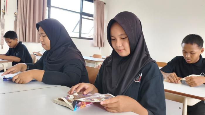 BACA BUKU - Siswi SRMP 12 Pati, Dinda Meila Azzahra (13), sedang membaca buku bersama kawan-kawannya di ruang kelas, Rabu (17/6/2026). (TribunJateng.com/Mazka Hauzan Naufal)