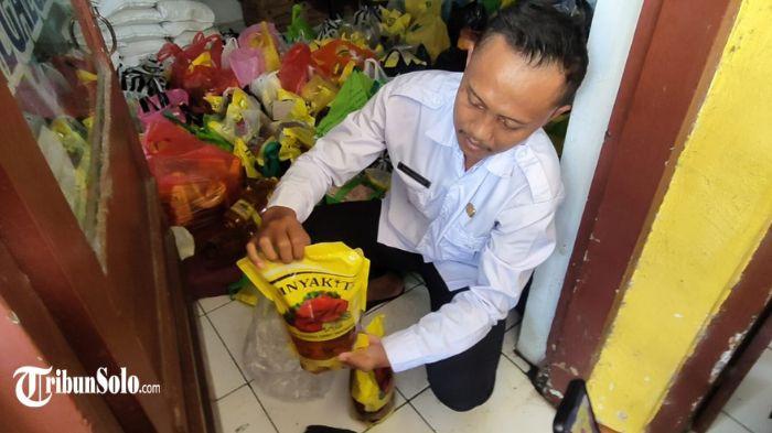 BAU MINYAK TANAH - Pegawai kelurahan Tegalgede menunjukan minyak goreng berbau minyak tanah dan solar di salah ruangan kantor Kelurahan Tegalgede Karanganyar, Rabu (24/6/2026). Polemik minyak goreng bantuan Bulog yang diduga berbau minyak tanah dan solar mencuat di Kabupaten Karanganyar.