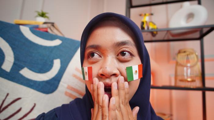PENDUKUNG MEKSIKO - Wanita asal Solo mengenakan stiker Meksiko di wajah sebagai bentuk dukungan dalam Piala Dunia 2026, di Kota Solo, Jawa Tengah, Rabu (17/6/2026).(Tribun-Video.com/Akmal Khoirul Habib)