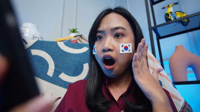 PENDUKUNG KOREA - Wanita asal Solo mengenakan stiker Korea Selatan di wajah sebagai bentuk dukungan dalam Piala Dunia 2026, di Kota Solo, Jawa Tengah, Rabu (17/6/2026).(Tribun-Video.com/Akmal Khoirul Habib)