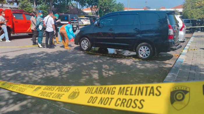 OLAH TKP - Petugas saat mengamankan TKP dengan memasang garis polisi di TKP parkiran Terminal 1 Bandara Juanda Surabaya, Rabu (24/6/2026).Mobil Innova plat merah milik Pemkab Bangkalan itu diketahui sudah parkir selama 4 hari.