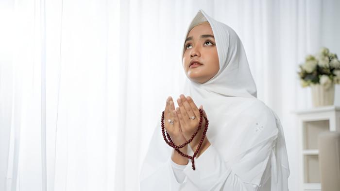 BERDOA- Ilustrasi seorang wanita muslim yang sedang berdoa. Tampak wanita tersebut memegang tasbih di tangannya.