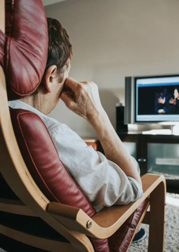 man sitting in a chair watching tv
