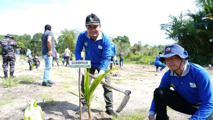 Dukungan Penuh Pemerintah Daerah: Plt. Kepala Dinas Lingkungan Hidup dan Kehutanan (DLHK) Provinsi Kepulauan Bangka Belitung, Bapak Amransyah Muslimin, S.T., M.T. (tengah), bertindak mewakili Gubernur Provinsi Kepulauan Bangka Belitung, turun langsung menggunakan cangkul untuk menanam bibit kelapa di area plot penanaman yang telah disediakan.