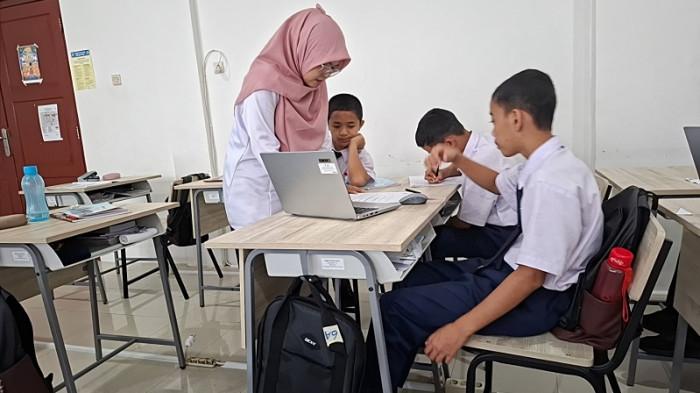 MEMAHAMI MATERI - Khoirida Hardini Kurniani (31) membimbing siswa memahami materi pelajaran di kelas Sekolah Rakyat Menengah Pertama (SRMP) 13 Banyumas, Kabupaten Banyumas, Jawa Tengah, Jumat (19/6/2026). Khoirida mengajar mata pelajaran Informatika dan Komputer sekaligus ekstrakulikuler.